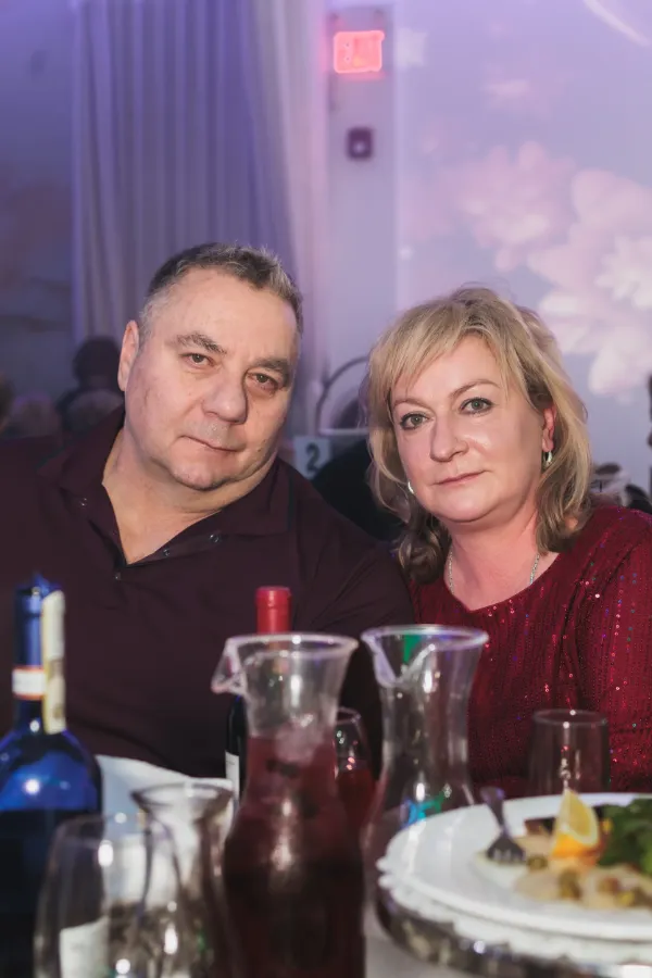 Couple matching burgundy outfits at table