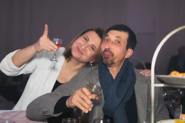 Playful couple woman thumbs up drinks