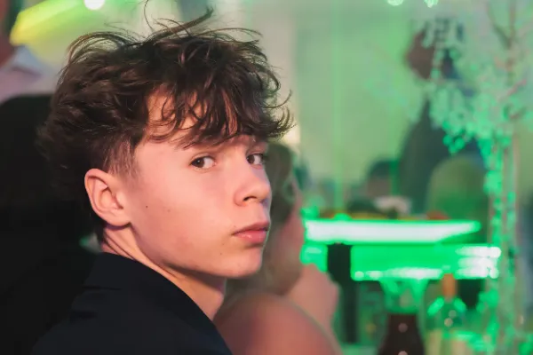 Teenage boy candid close portrait green lighting