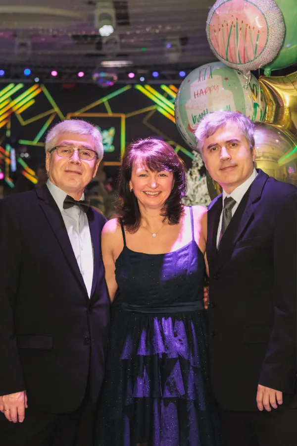 Three guests birthday woman two men balloons