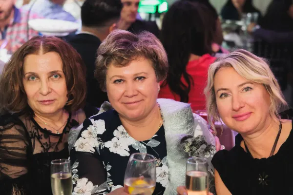 Three women champagne flutes seated at table