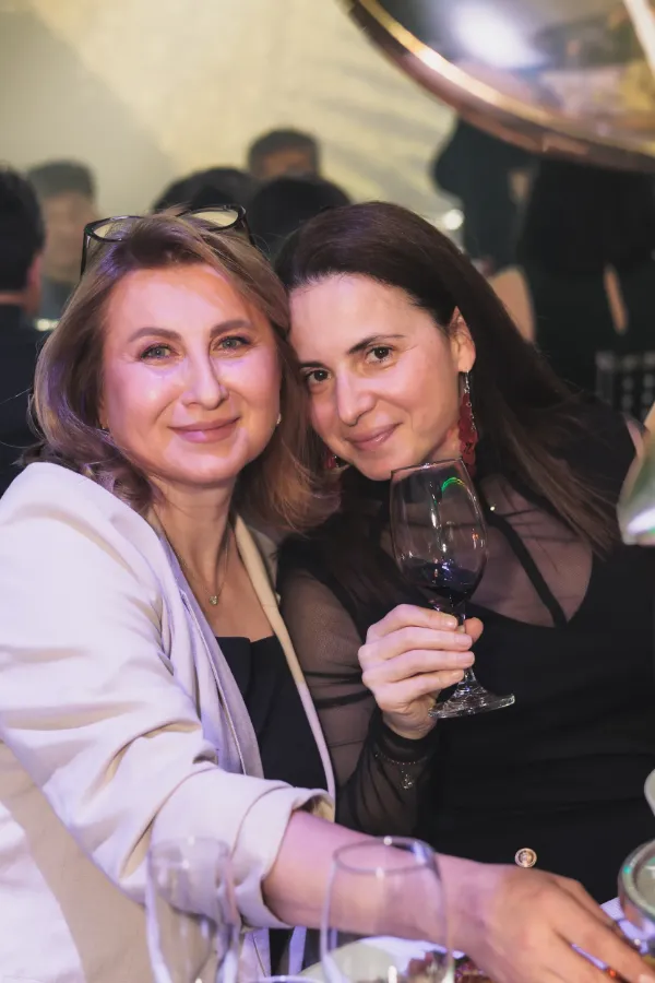 Two women smiling red wine