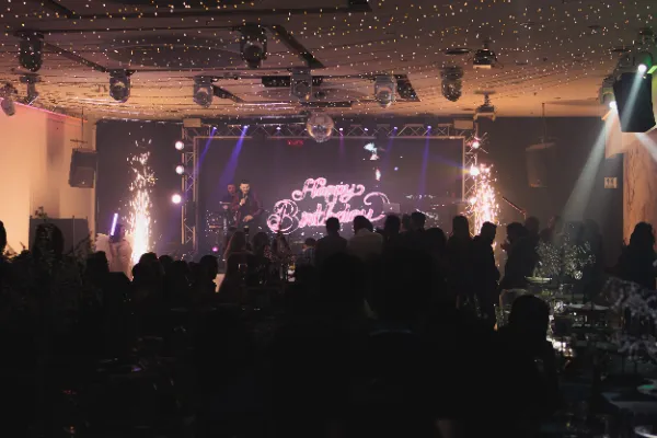 Venue wide shot happy birthday neon stage fireworks
