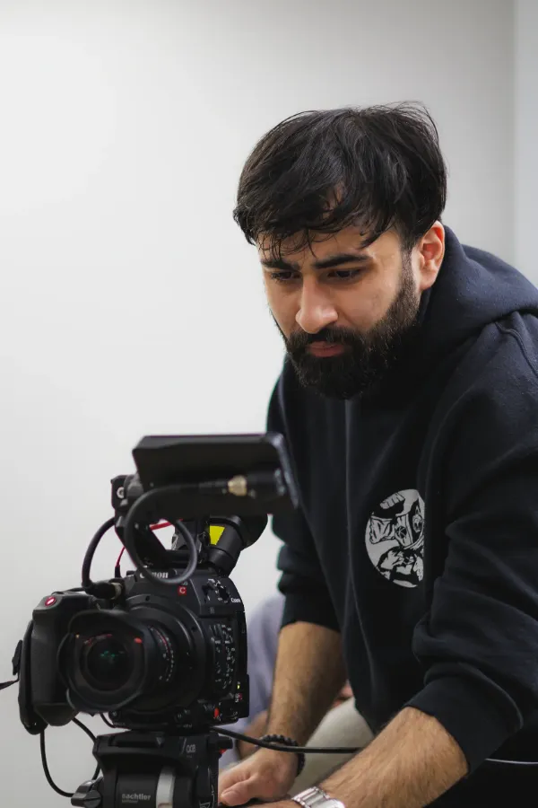 Bts cinematographer looking through canon cinema camera