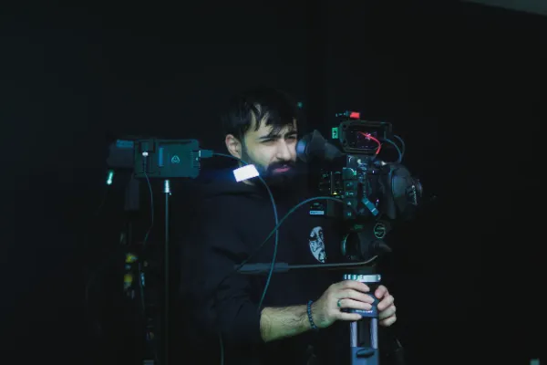 Bts cinematographer operating camera dark studio