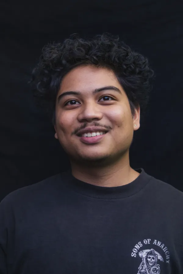 Bts crew member curly hair smiling dark background portrait