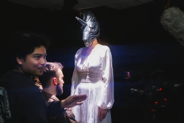 Bts director adjusting masked actress white dress onset