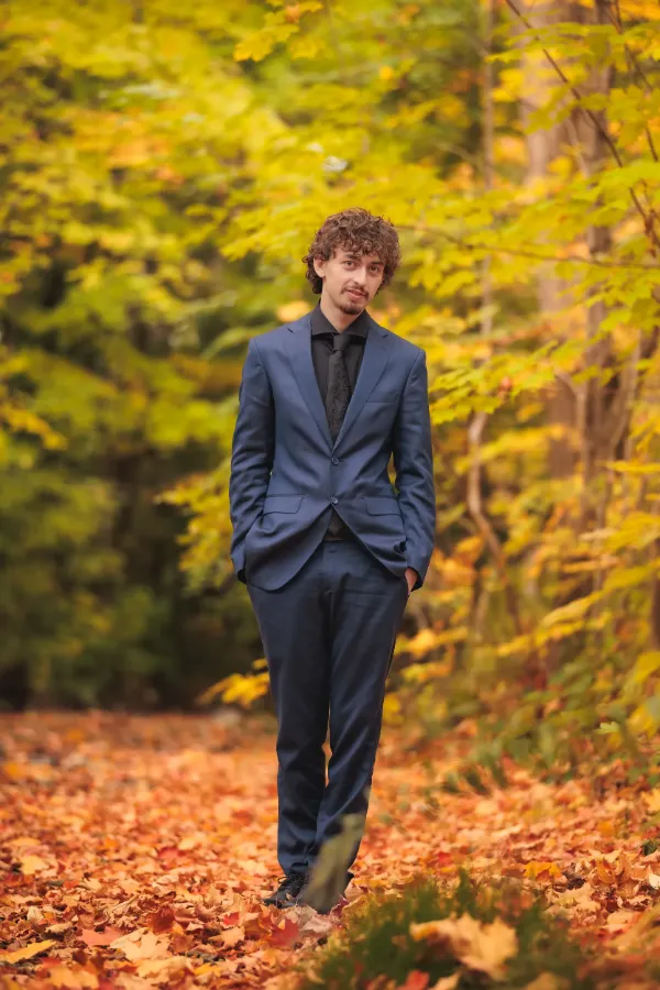 Grad guy blue suit full body autumn forest floor