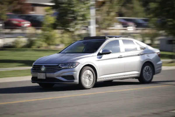 Silver volkswagen jetta panning shot suburban street