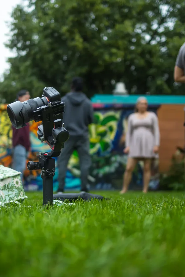Gimbal camera low angle grass female actor standing outdoor mural bg