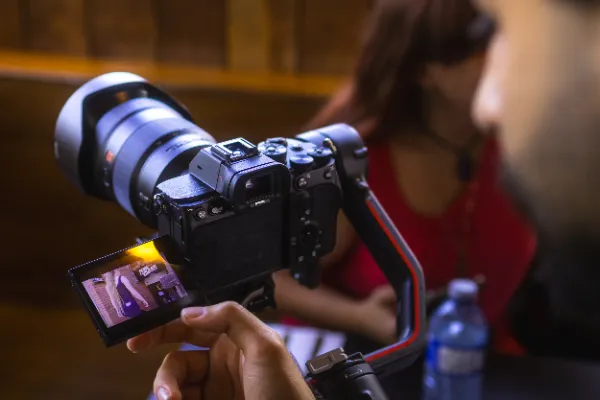 Gimbal camera monitor showing live feed restaurant female actor bg