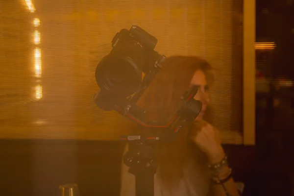 Sony camera on gimbal golden restaurant light female crew bg