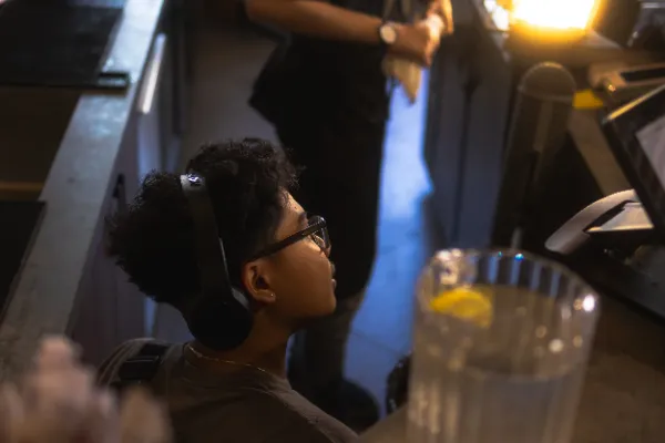 Sound recordist headphones glasses watching monitor restaurant set