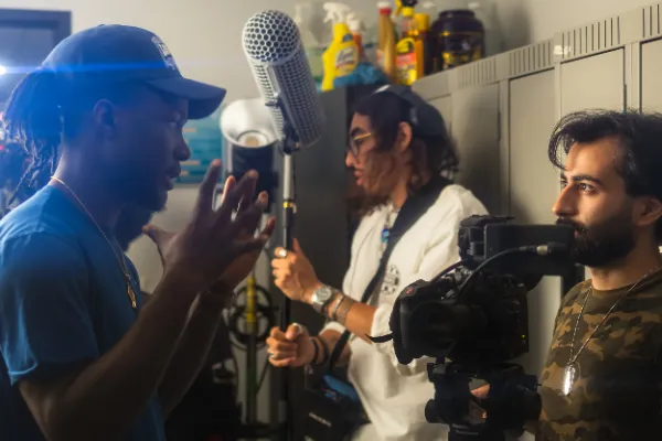 Director gesturing to talent boom mic camera locker room set