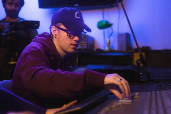 Director glasses cap adjusting faders mixing console studio