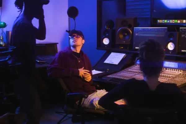 Director red hoodie glasses relaxing mixing console studio session