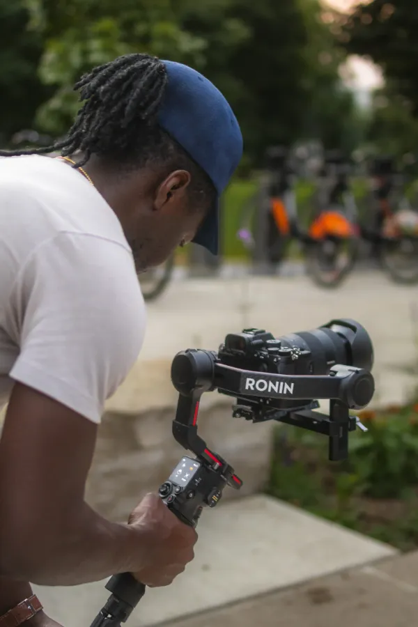 Cinematographer dreadlocks operating dji ronin gimbal park path