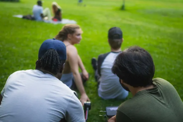 Crew watching actors from behind on park grass overcast