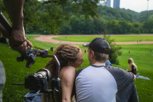 Gimbal closeup filming two actors intimate park hillside scene