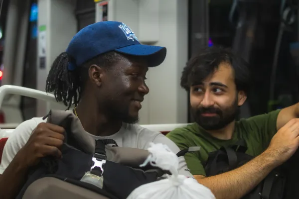 Two crew members laughing on toronto transit bus after shoot