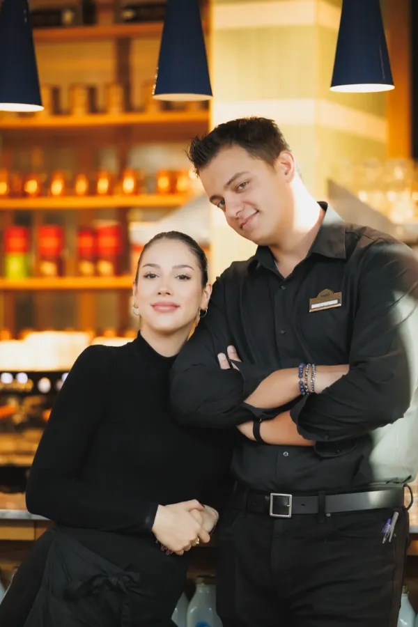 Couple restaurant staff black uniforms bar portrait