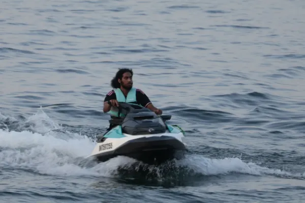 Man teal life jacket riding seadoo jet ski lake
