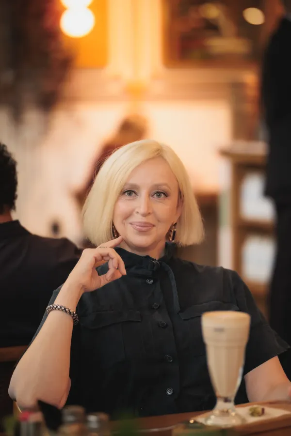 LF blonde bob black dress ok gesture latte cafe portrait 07
