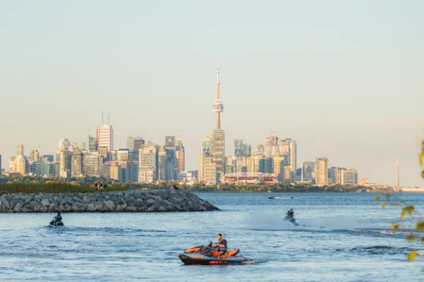 Toronto skyline cn tower lake ontario jetskis rock jetty daytime