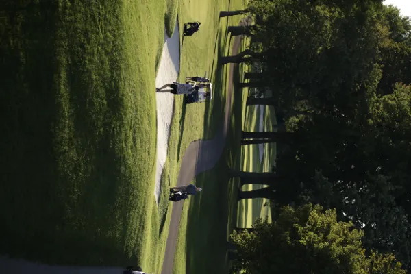 Golf course aerial bunker sand trap players cart golden hour